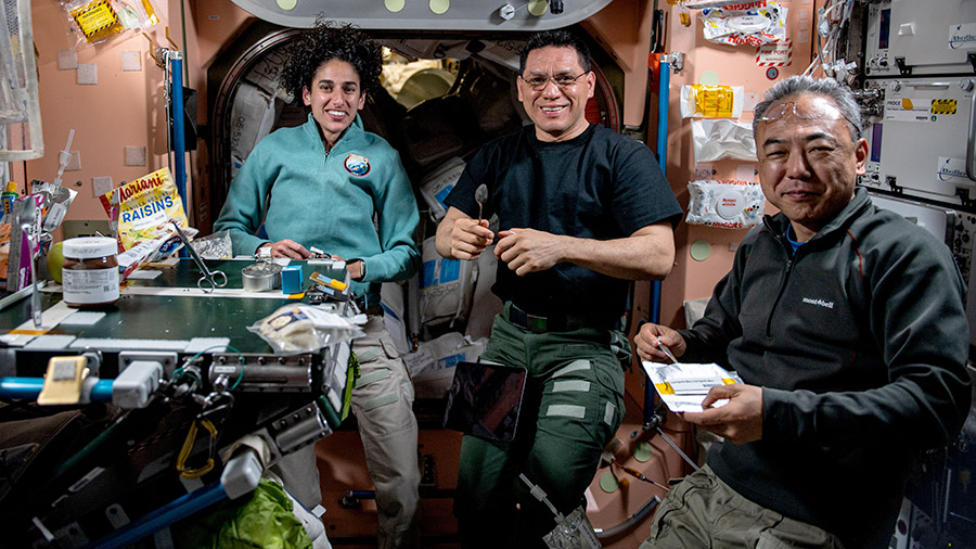 Expedition 69 astronauts (from left) Jasmin Moghbeli, Frank Rubio, and Satoshi Furukawa join each other for lunch aboard the space station's Unity module.