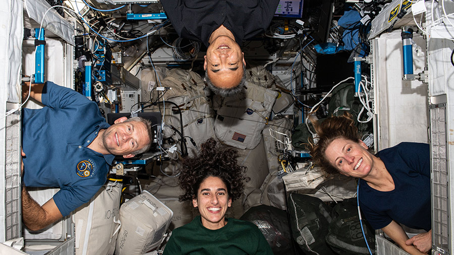 Four Expedition 70 crew members pose for a portrait inside their crew quarters. Clockwise from bottom are, astronauts Jasmin Moghbeli, Andreas Mogensen, Satoshi Furukawa, and Loral O'Hara.