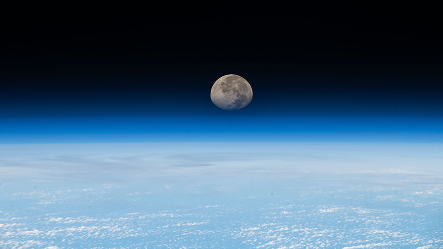 A waning gibbous moon sets just beyond Earth's horizon in this photograph from the space station soared above the South Pacific Ocean.