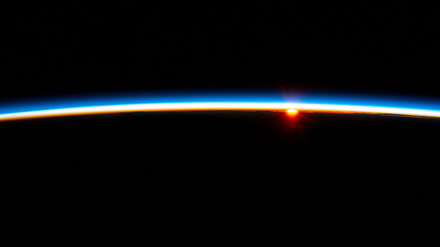 The last rays of an orbital sunset fade below Earth's horizon illuminating the atmosphere in this photograph from the International Space Station as it soared above the Atlantic Ocean.