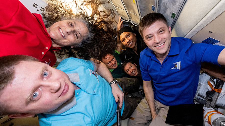 Six Expedition 71 crew members pose for a portrait inside the Rassvet module moments before three Soyuz MS-26 crew members enter the space station.