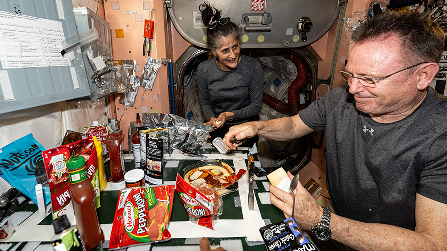 NASA astronauts Suni Williams and Butch Wilmore make pizza aboard the International Space Station's galley located inside the Unity module.