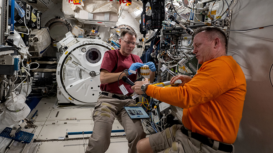 Astronauts (from left) Nick Hague and Butch Wilmore partner together inside the Kibo laboratory module on space biology research.