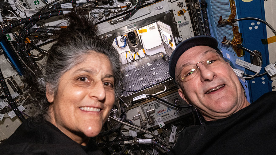 NASA astronauts Suni Williams and Don Pettit pose for a portrait in front of the Advanced Plant Habitat designed to support commercial and fundamental plant research in microgravity.