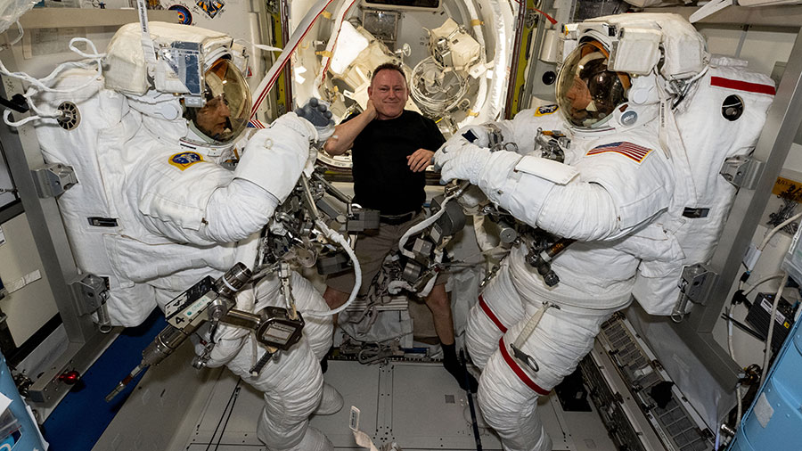 NASA astronaut Butch Wilmore (center) assists Suni Williams (left) and Nick Hague (right), both NASA astronauts, as they prepare to evaluate their spacesuits in a pressurized configuration.