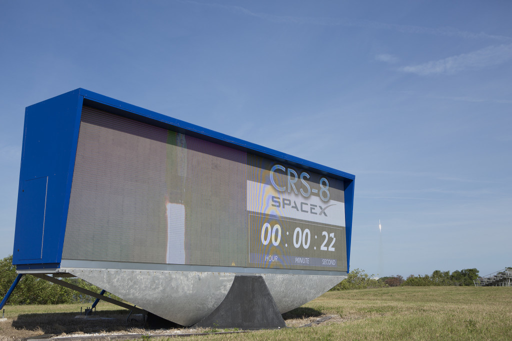 SpaceX Falcon 9 rocket lifts off behind the countdown clock