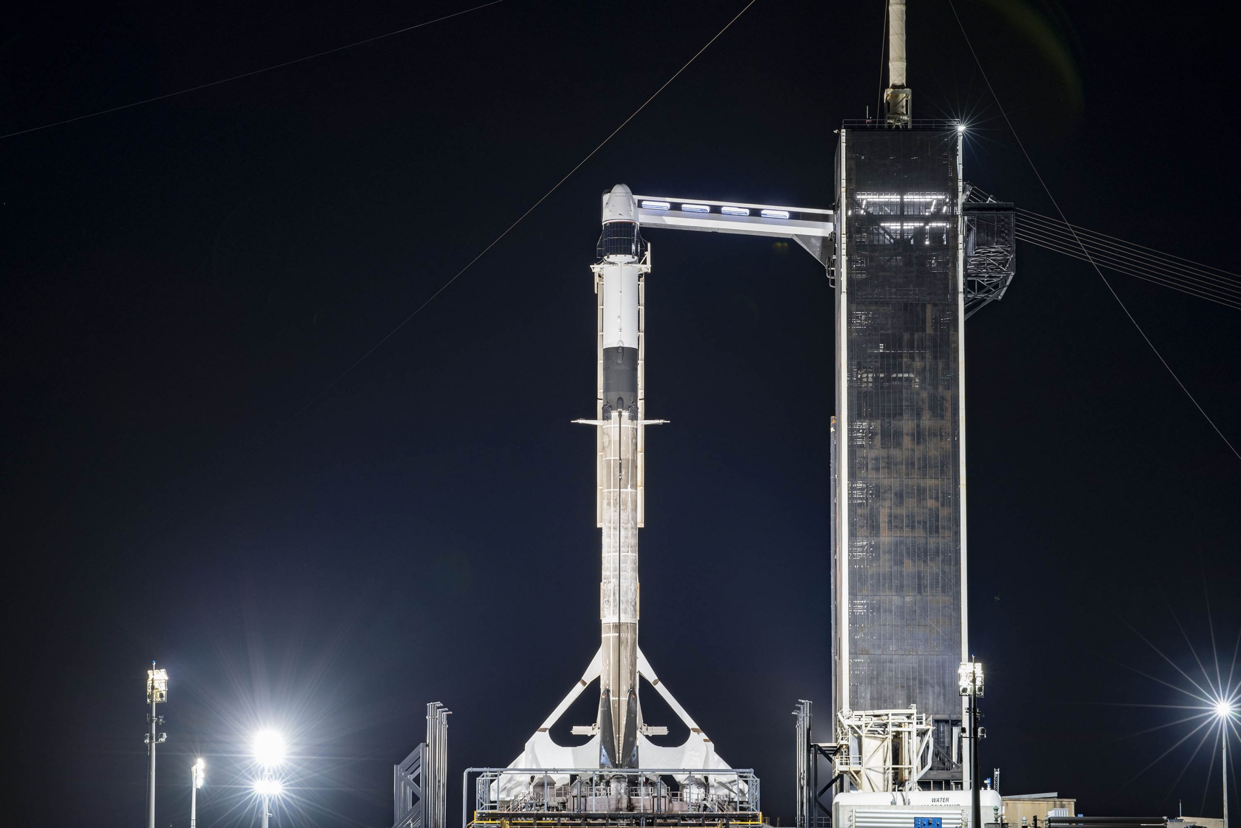 A SpaceX Falcon 9 rocket and Cargo Dragon spacecraft stand ready for liftoff for the company's CRS-21 launch.