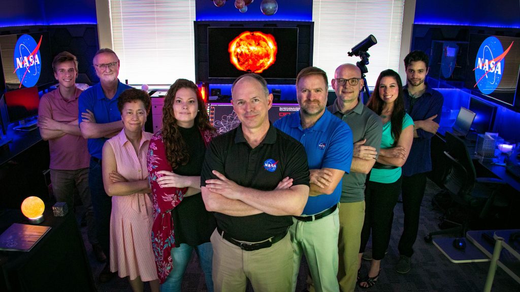 Members of the lab stand in a V-shape formation in the NASA STEAM Innovation Lab