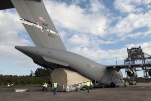 Workers unload NASA's TDRS-L satellite from the hold of a C-17 transport aircraft