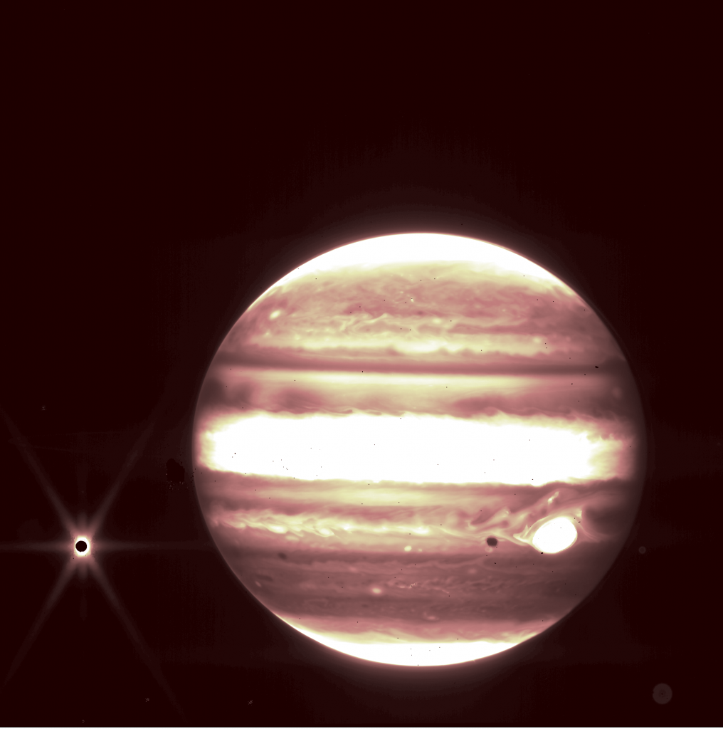 The background of space is black. Jupiter is on the right with bands of brown and white. On the left, the moon Europa is a very small, dark circle with a bright spot of light around with, with six diffraction spikes.