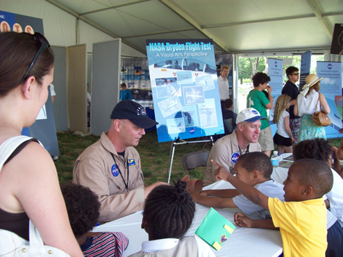 NASA pilots talk to the public at an air show exhibit.