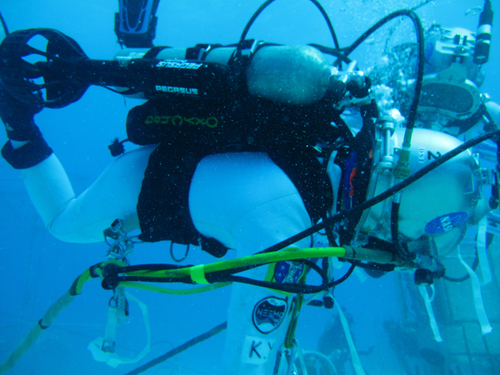 Aquanaut Kimiya Yui (JAXA) uses a jetpack while performing tasks underwater.