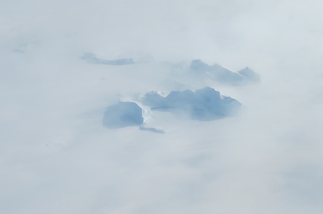 Icebergs in a northwest Greenland fjord shrouded in fog.