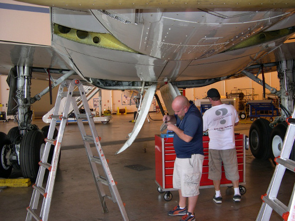 University of Kansas Ben Panzer and NASA Tech Donny Bailes work the KU and Snow Radar instruments antennas installation in the DC-8 wing root area