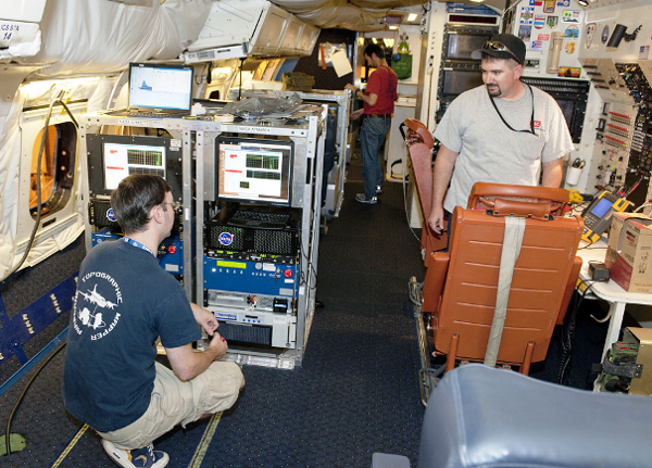 Avionics technician Brad Grantham (right) and Airborne Topographic Mapper team members Matt Linkswiler and Robert Harpold prepare instruments for the IceBridge campaign.