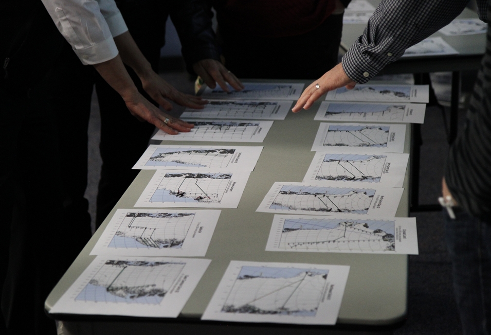 Science team members sort through printed copies of proposed flight lines.