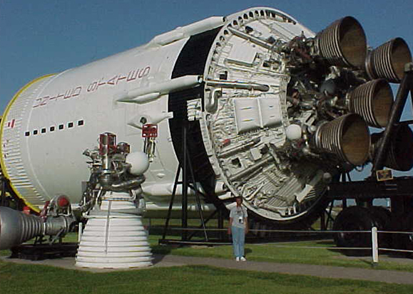 Denise stands near a Saturn V