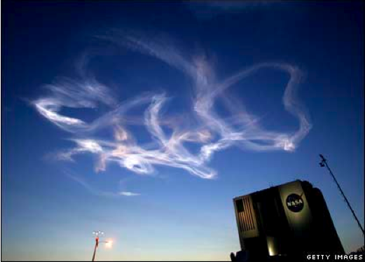 Rocket trails move sideways through the sky